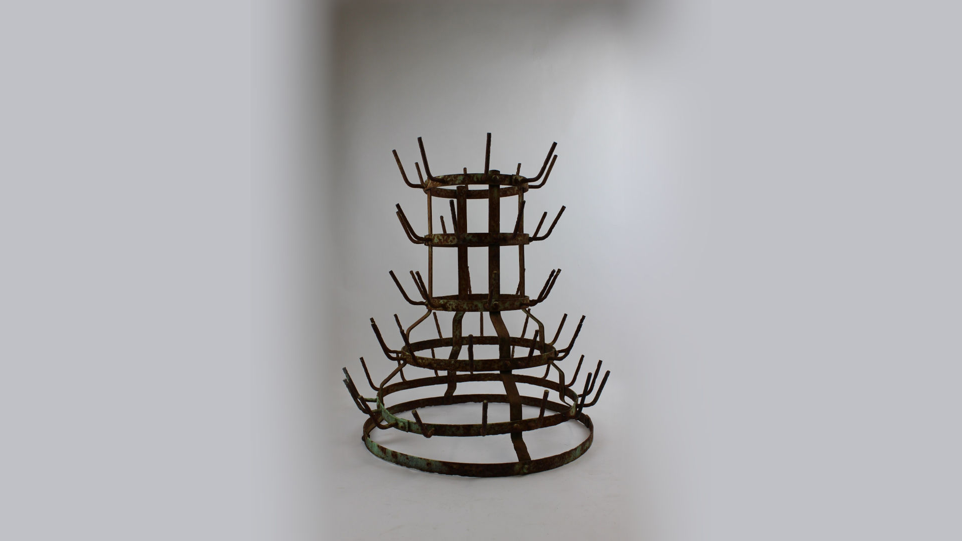 Foto: ein trapezförmiges, rundes Objekt aus Metall mit nach oben stehenden Haken