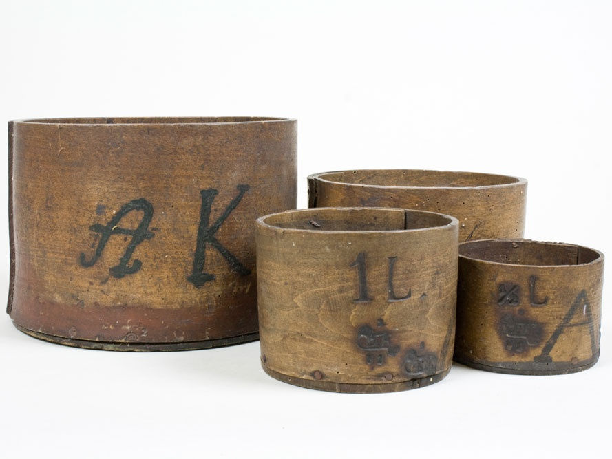 Foto: Vier Behälter aus Holz, auf dem mittleren Gefäß befinden sich die Buchstaben "1L"